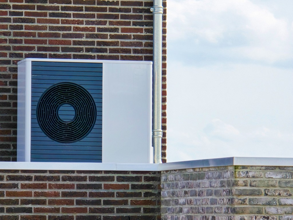 Air source heat pump installed on brick wall